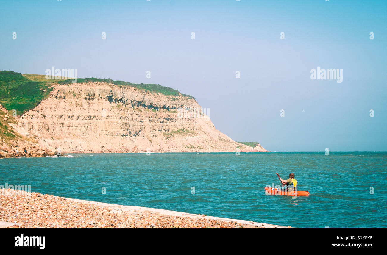A canoeist paddles along the cliff faced coastline at Rock a nor, Hastings UK 2009 - Smartphone Captured Stock Image