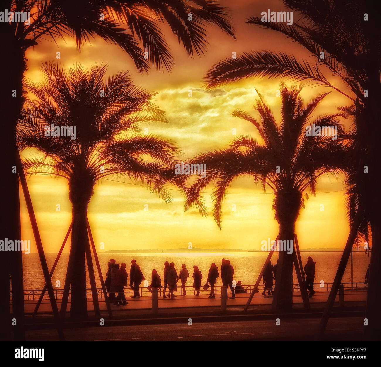 People walking along a southern French promenade as the sun sets. An atmospheric image with lots of potential uses?! Photo ©️COLIN HOSKINS. - Smartphone Captured Stock Image