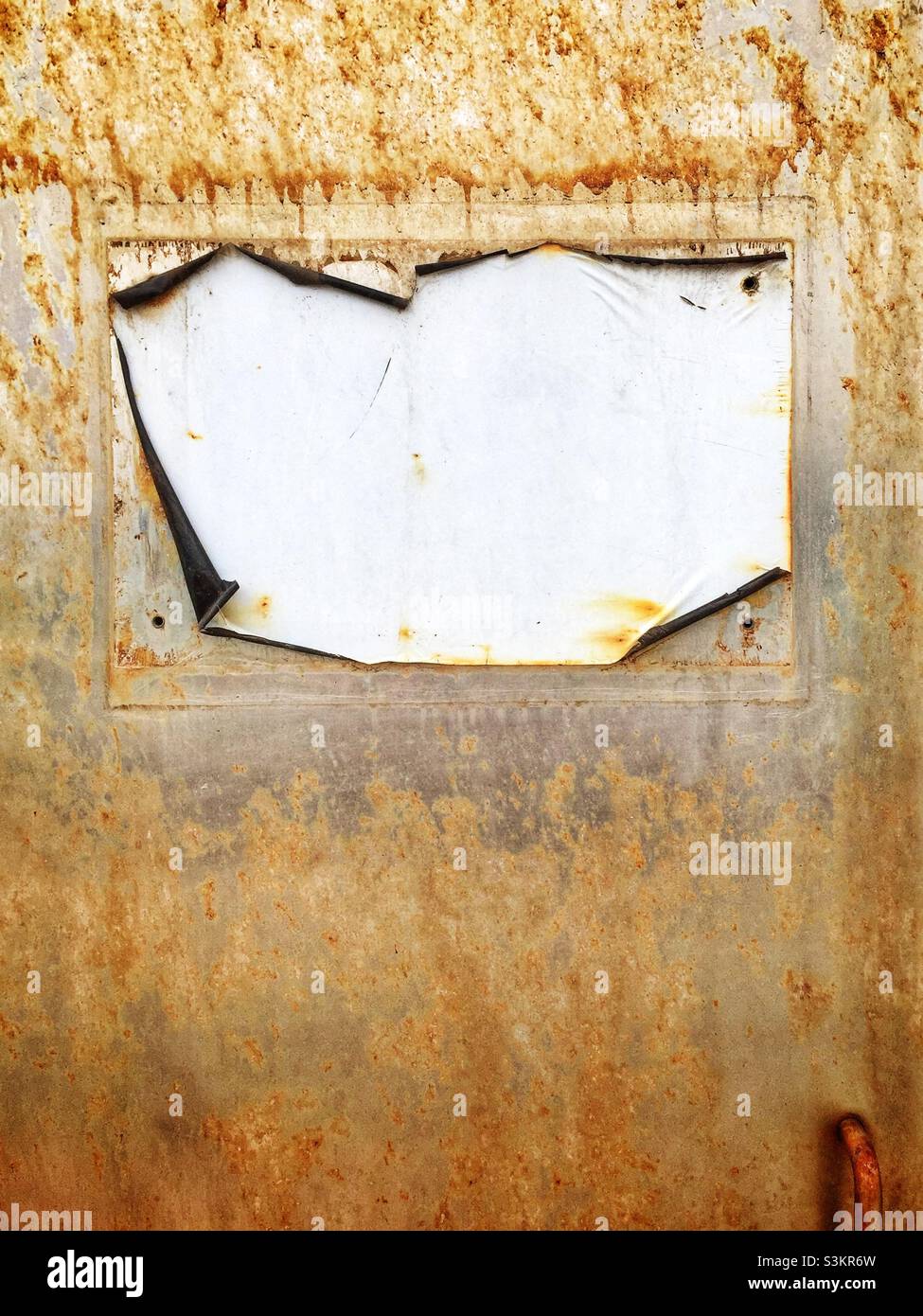 Detail of a faded and peeling sign on a rusting metal door, Hong Kong - Smartphone Captured Stock Image