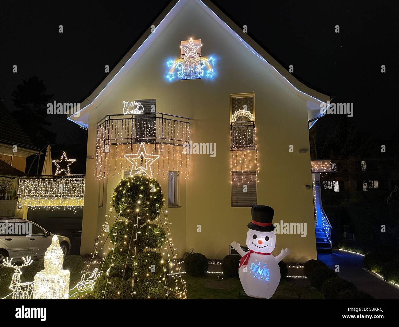 Illuminated Christmas decoration on the family house in village Urdorf, Switzerland during night . Stock Photo