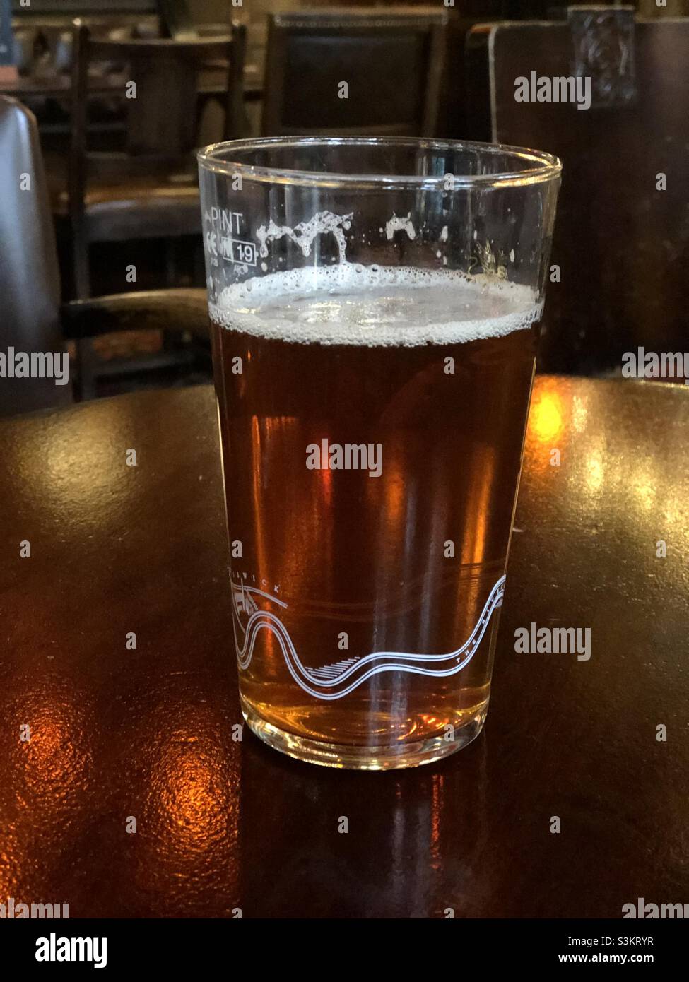 A partdrunk pint of bitter beer on a pub table in London Stock Photo
