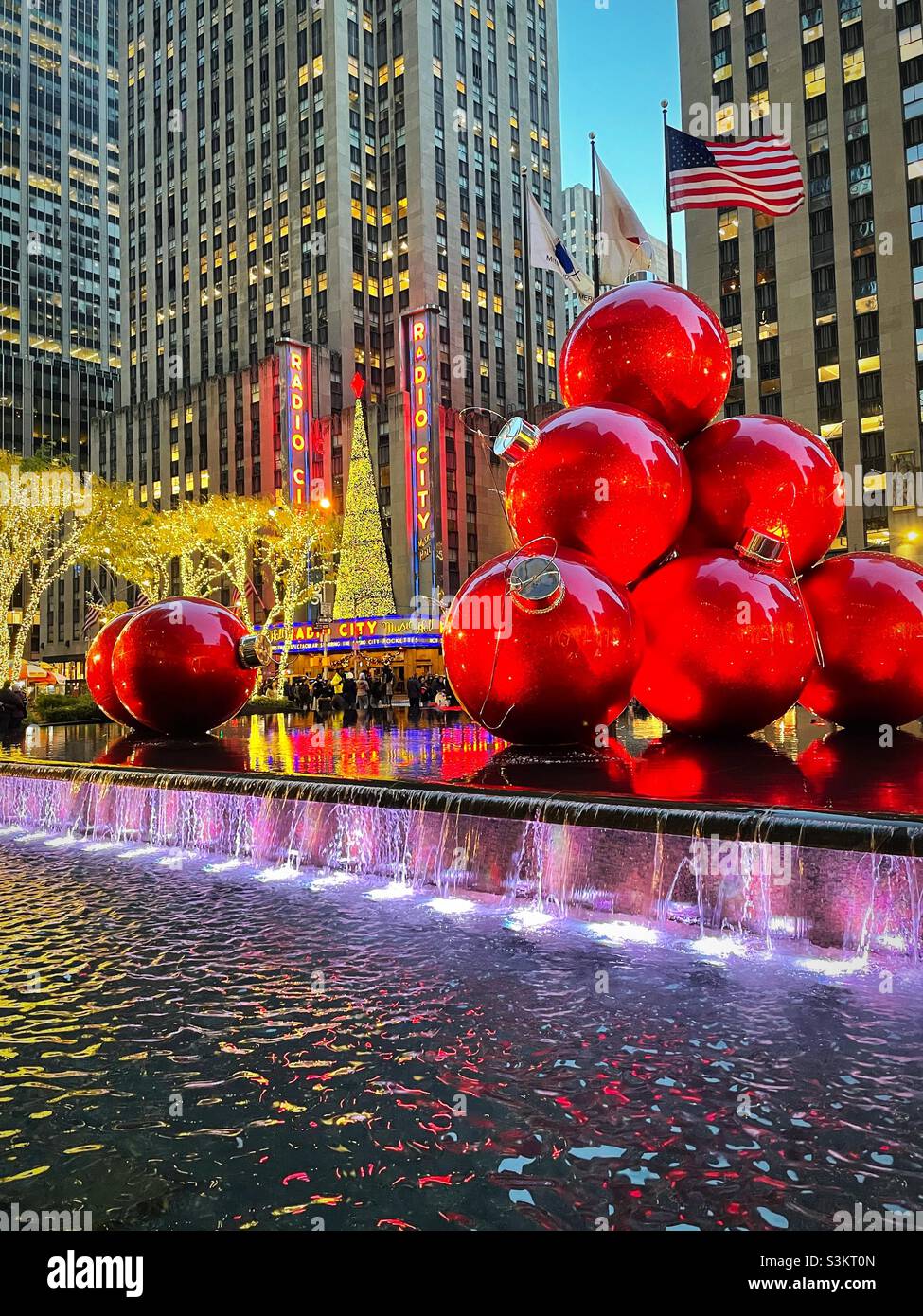 2021, giant Christmas tree ornaments piled high in a reflecting pool at 1251 Avenue of the Americas across from radio city music Hall during the holiday season, NYC, USA - Smartphone Captured Stock Image