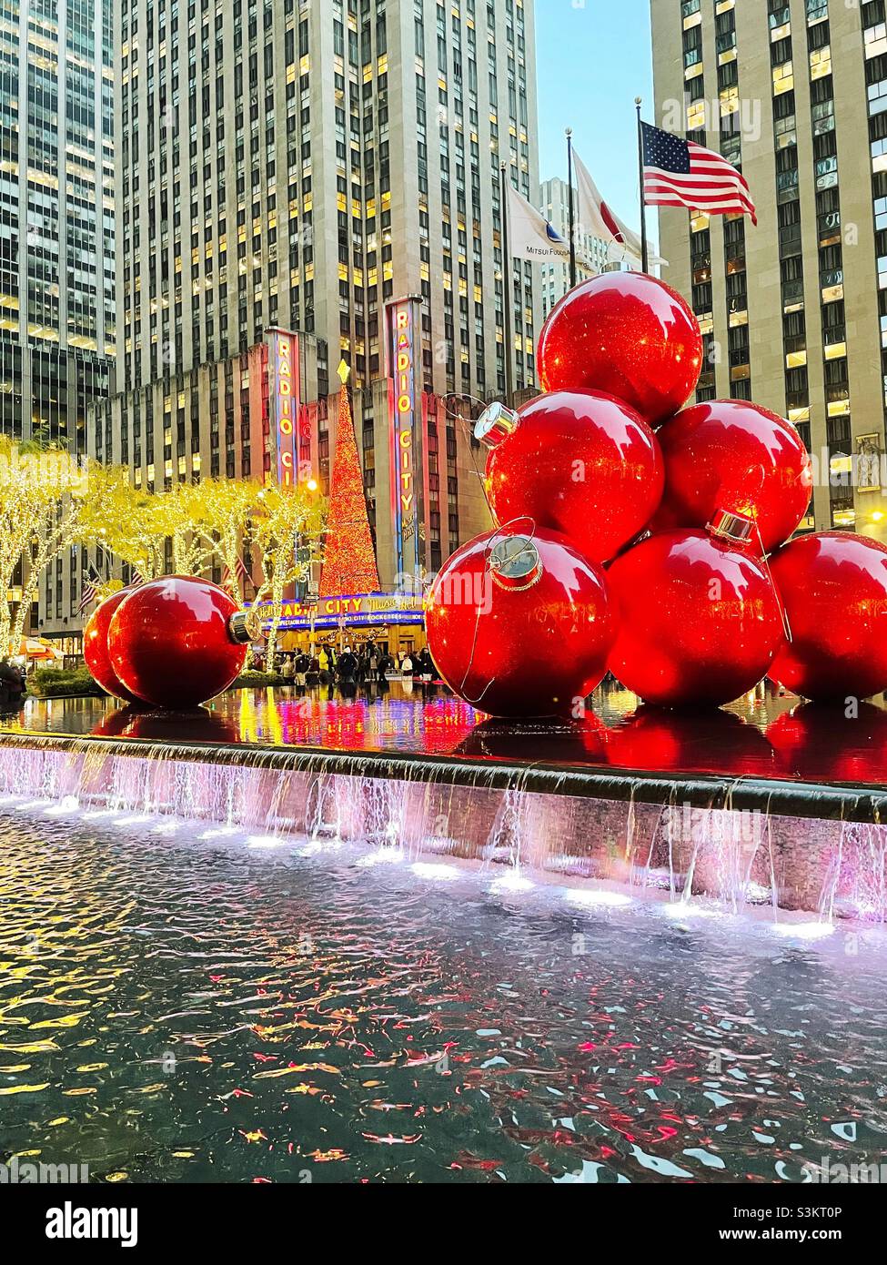 Giant Christmas tree ornaments are piled high in reflecting pool across from radio city music Hall during the holiday season, 2021, new York city, United States - Smartphone Captured Stock Image