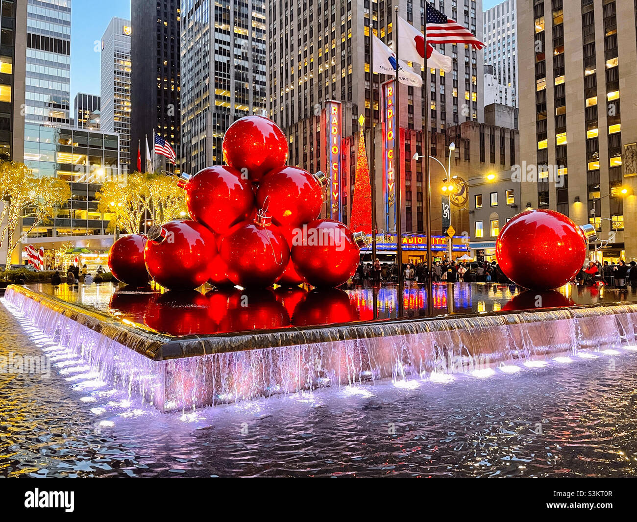 Giant Christmas tree ornaments are piled high in reflecting pool across from radio city music Hall during the holiday season, New York City, United States, 2021 - Smartphone Captured Stock Image