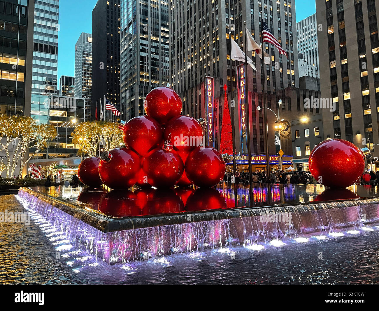 During the Christmas season giant Christmas tree ornaments are piled high and reflecting pool across from radio city music Hall, new York city, United States, 2021 - Smartphone Captured Stock Image