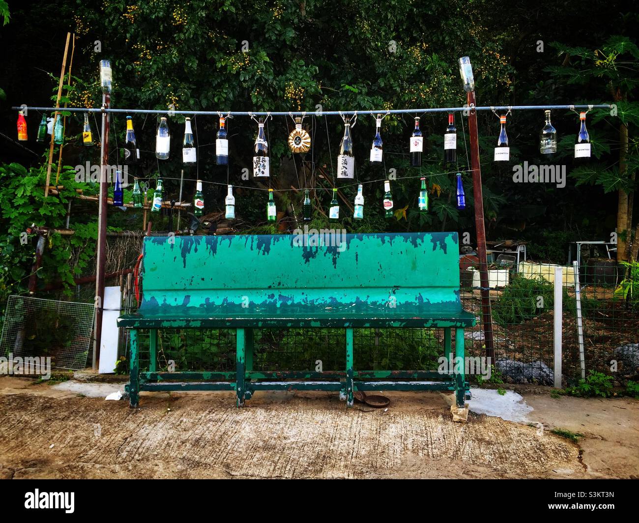 Hanging bottles and a public bench seat, Tai O, Lantau Island, Hong Kong - Smartphone Captured Stock Image