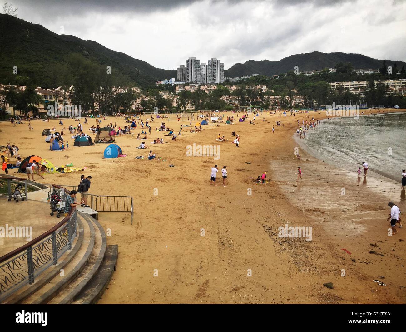 Domestic tourists visit Discovery Bay's man-made Tai Pak Beach, Lantau Island, Hong Kong - Smartphone Captured Stock Image