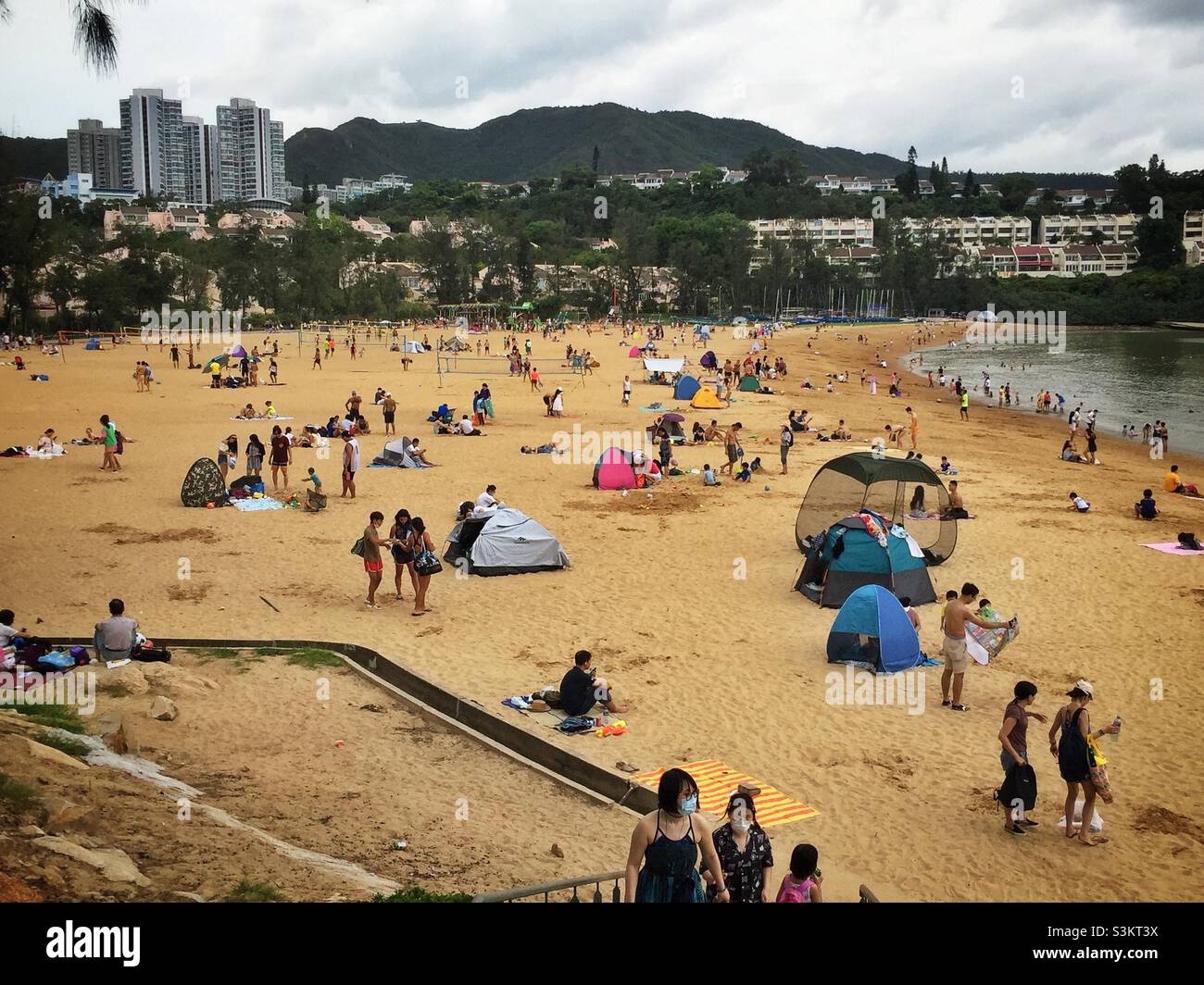 Domestic tourists visit Discovery Bay's man-made Tai Pak Beach, Lantau Island, Hong Kong - Smartphone Captured Stock Image