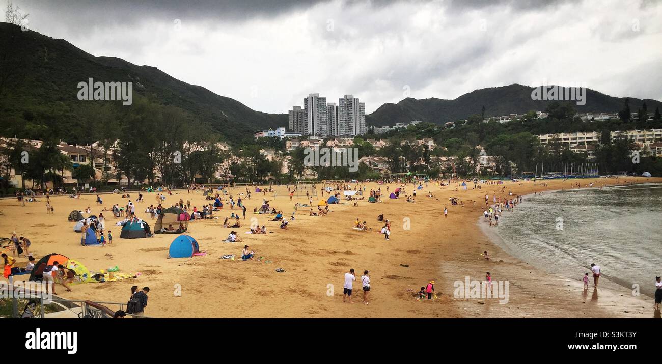 Domestic tourists visit Discovery Bay's man-made Tai Pak Beach, Lantau Island, Hong Kong - Smartphone Captured Stock Image