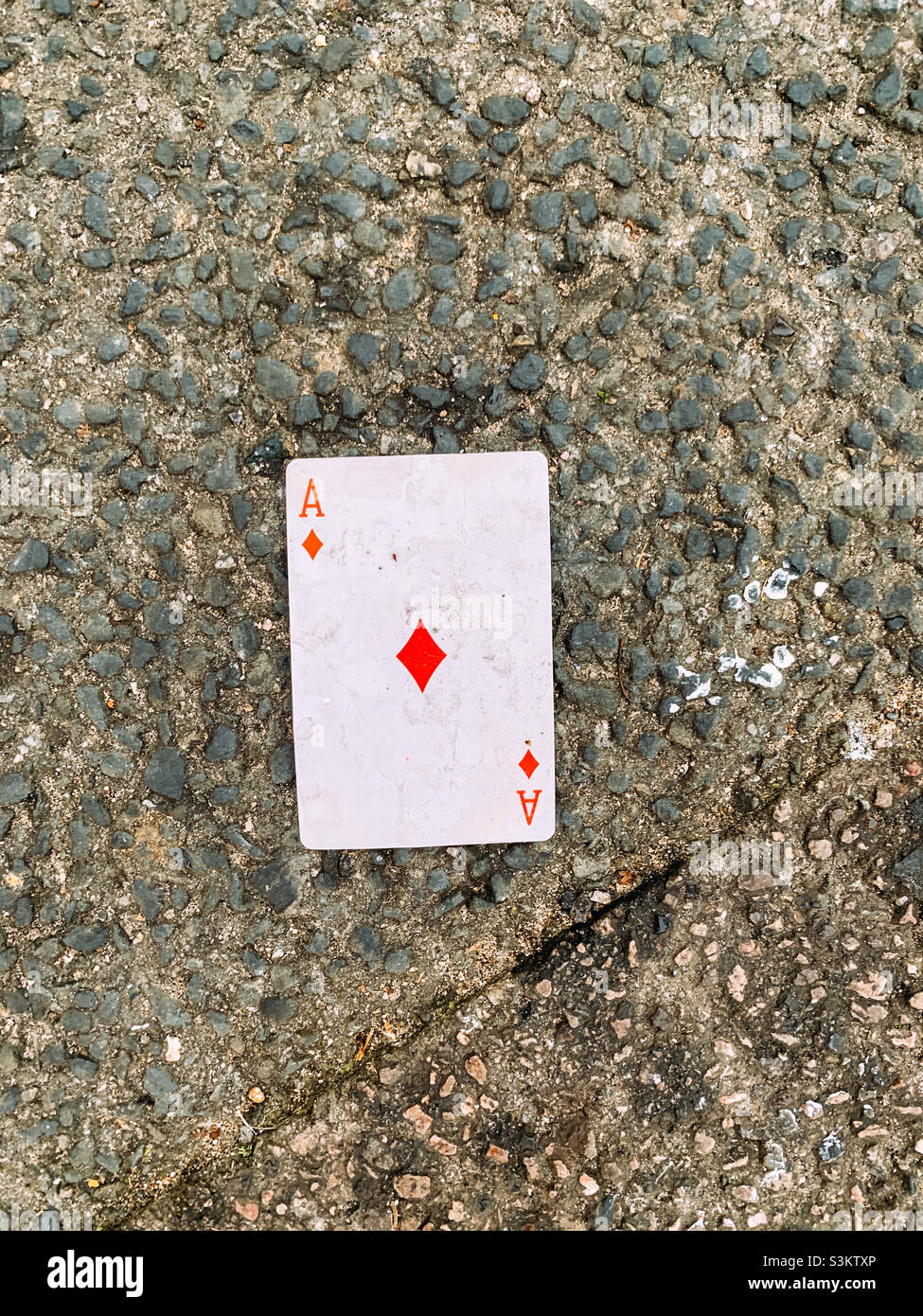 Dirty playing card left on the pavement - Smartphone Captured Stock Image