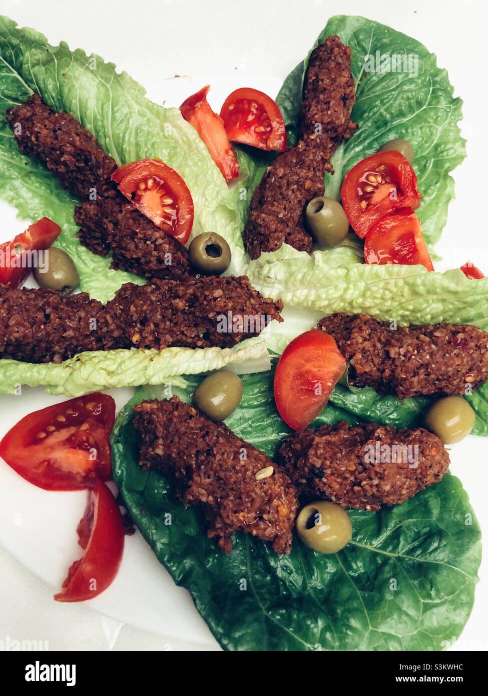 Turkish Vegan dish called cig kofte that is made of bulgur wheat and some herbs and served with fresh lettuces - Smartphone Captured Stock Image