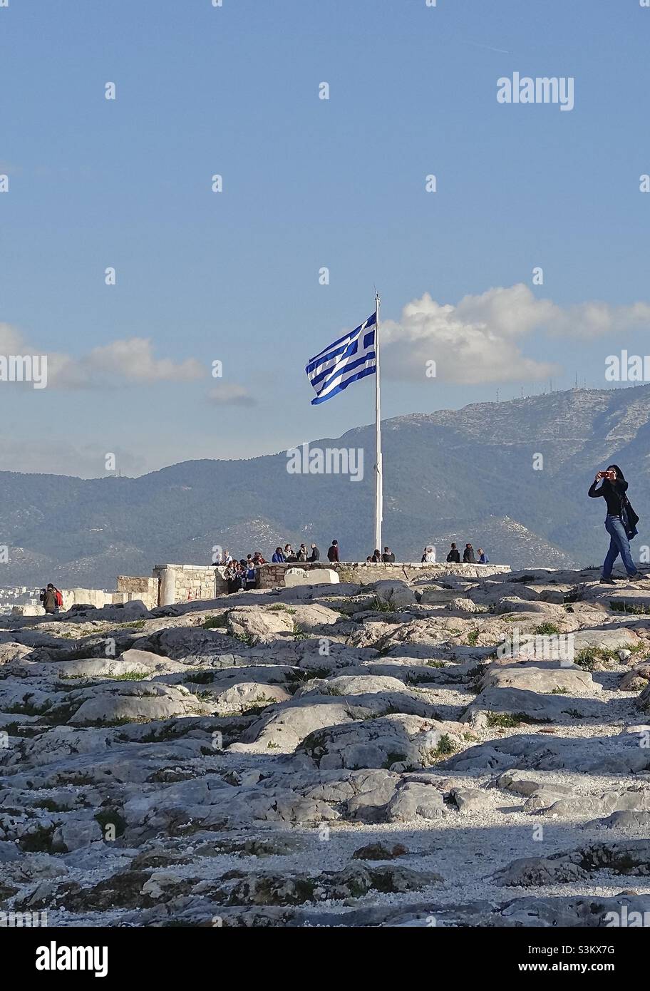 Winter scene on the Acropolis, Athens, Greece, close to the Parthenon. Visitors are grouped near the Greek flag in a small Belvedere to admire the views. Behind is Hymettus (1026m), a mountain range. Stock Photo