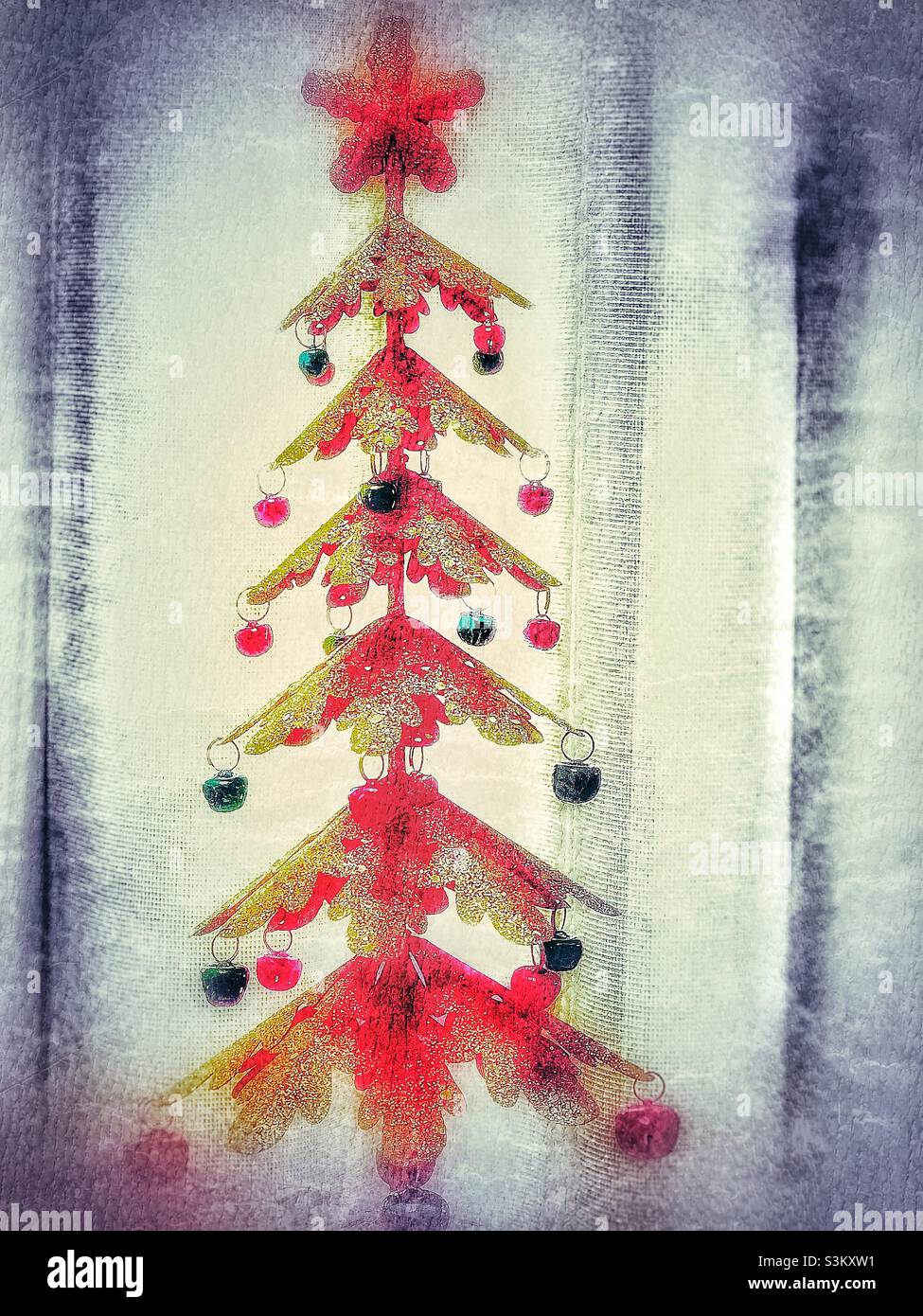 A small metallic, tabletop Christmas tree with red and green ornaments. - Smartphone Captured Stock Image