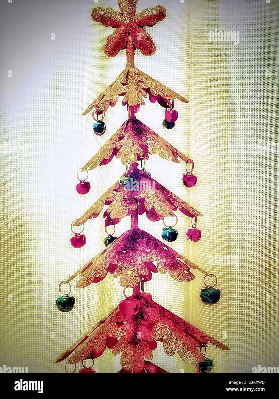A small metallic, tabletop Christmas tree with red and green ornaments. - Smartphone Captured Stock Image