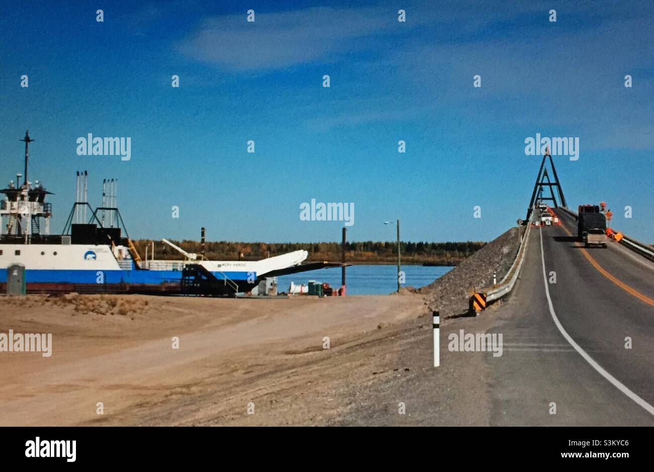 Retired ferry and the The Deh Cho Bridge, cable-stayed bridge ,Mackenzie River, Yellowknife Highway, Fort Providence, Northwest Territories, Canada Stock Photo