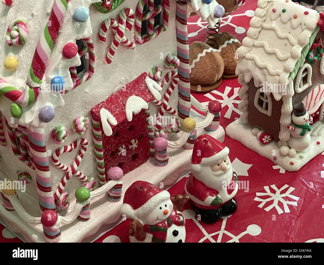 A ceramic gingerbread house and other Christmas decorations and knick knacks on a dining room table in a home in Utah, USA. - Smartphone Captured Stock Image