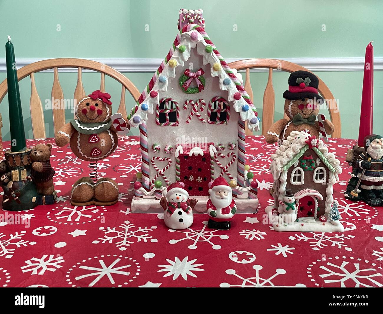 A ceramic gingerbread house and other Christmas decorations and knick knacks on a dining room table in a home in Utah, USA. - Smartphone Captured Stock Image