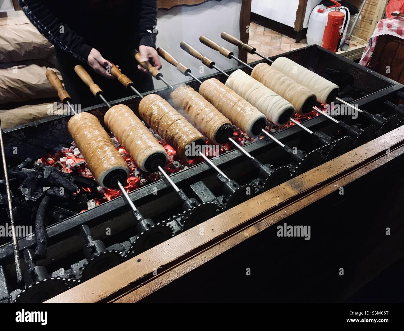 Baking split-cake called kurtoskalacs in the street in Hungary - Smartphone Captured Stock Image