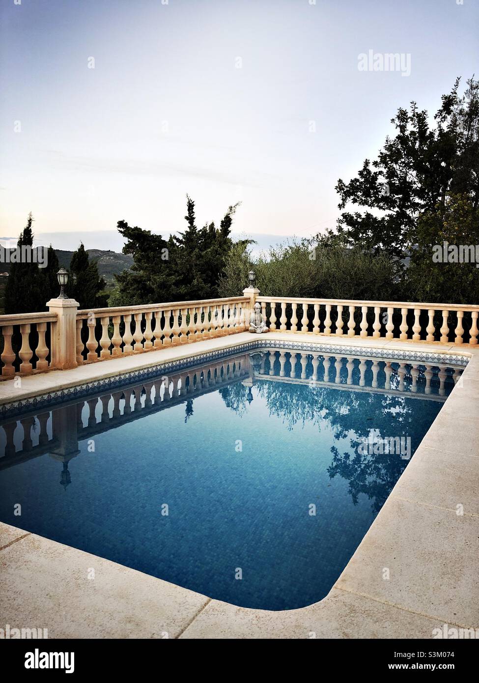 Swimming pool with reflections of trees in Spain Stock Photo