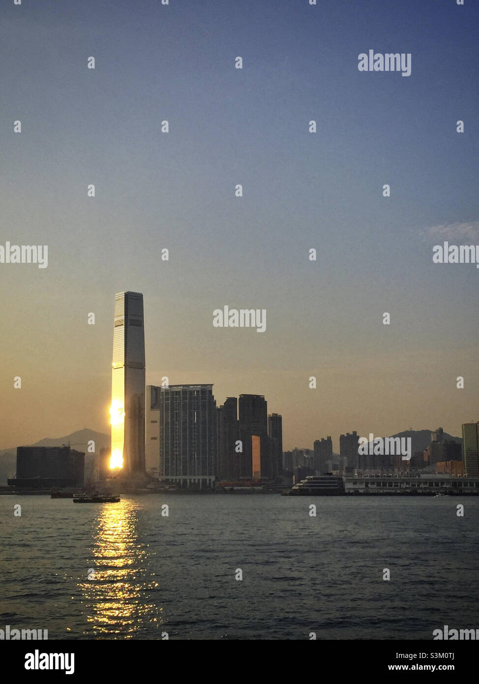 The setting sun reflected in the façade of the International Commerce Centre (ICC), Hong Kong's tallest skyscraper - Smartphone Captured Stock Image