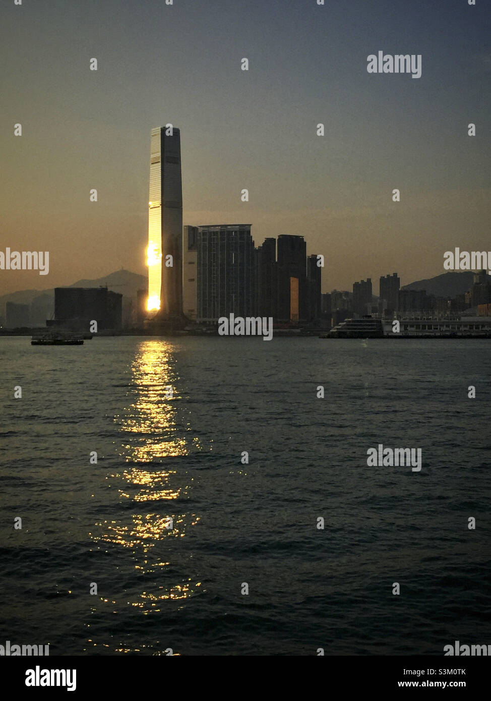 The setting sun reflected in the façade of the International Commerce Centre (ICC), Hong Kong's tallest skyscraper - Smartphone Captured Stock Image