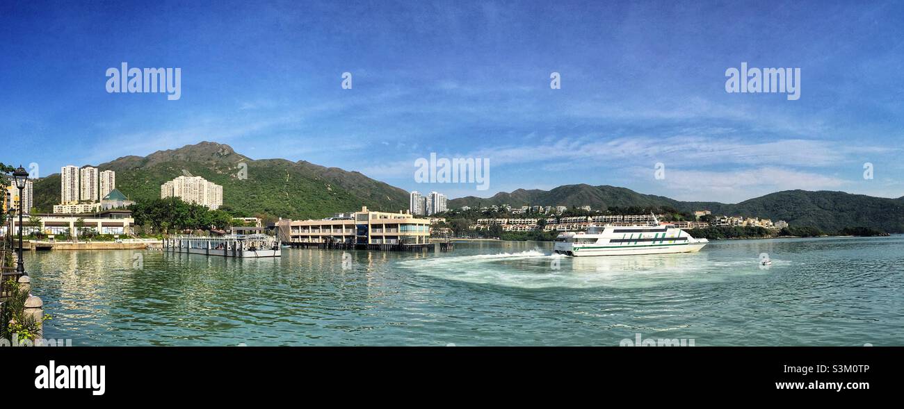 A ferry leaves the pier bound for Hong Kong Island from Discovery Bay, Lantau Island, Hong Kong - Smartphone Captured Stock Image