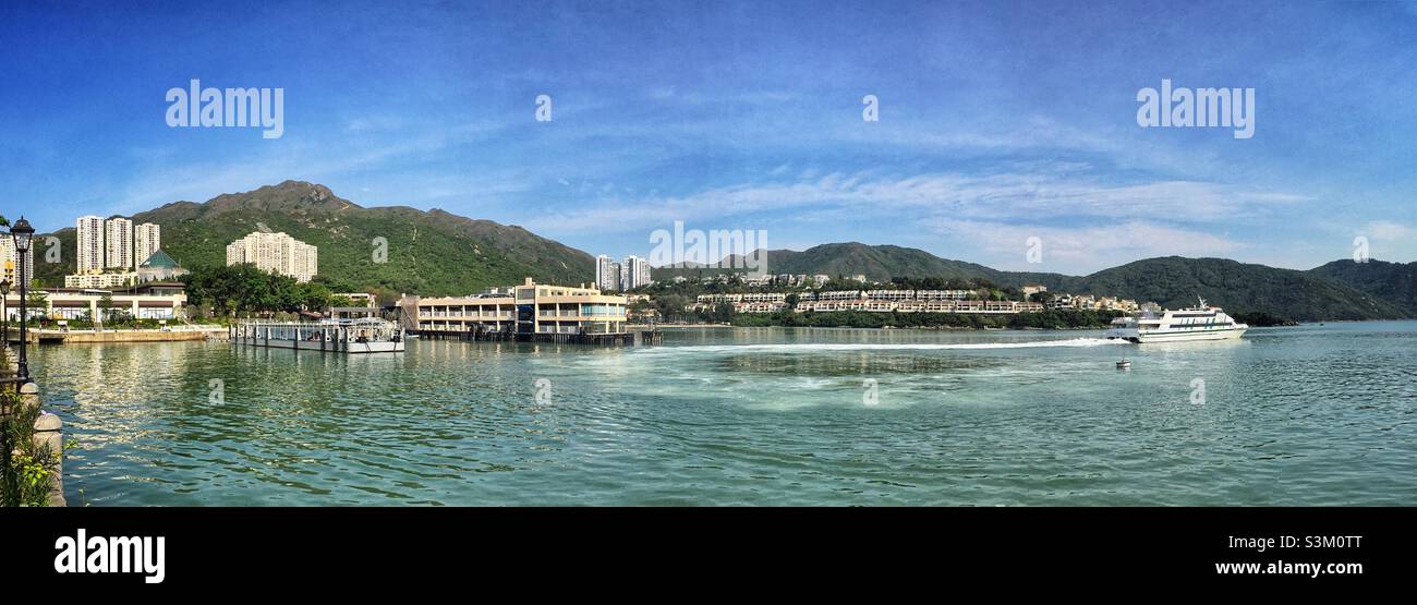 A ferry leaves the pier bound for Hong Kong Island from Discovery Bay, Lantau Island, Hong Kong - Smartphone Captured Stock Image