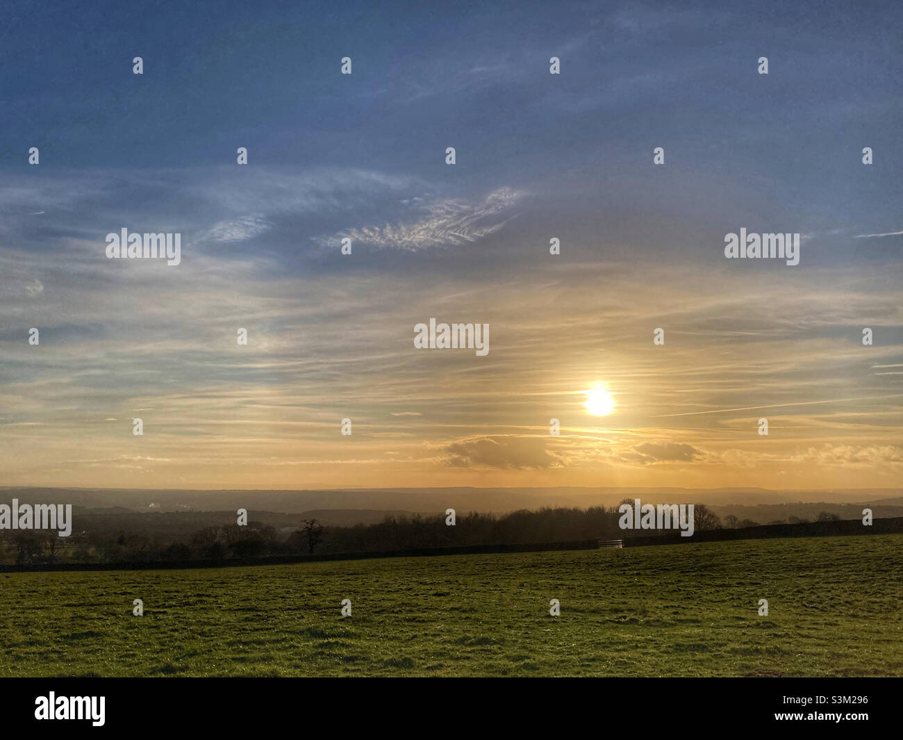 Sun setting over fields in Guiseley West Yorkshire Stock Photo