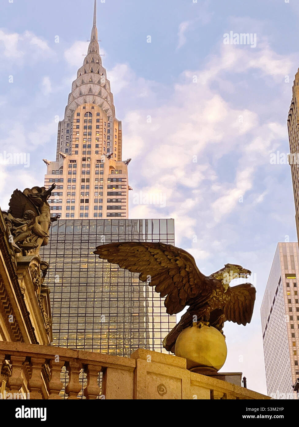 A giant cast iron eagle is at the corner entrance of Vanderbilt Avenue and East 42nd St. at Grand Central terminal with the Chrysler building in the background, 2021, New York City, United States Stock Photo