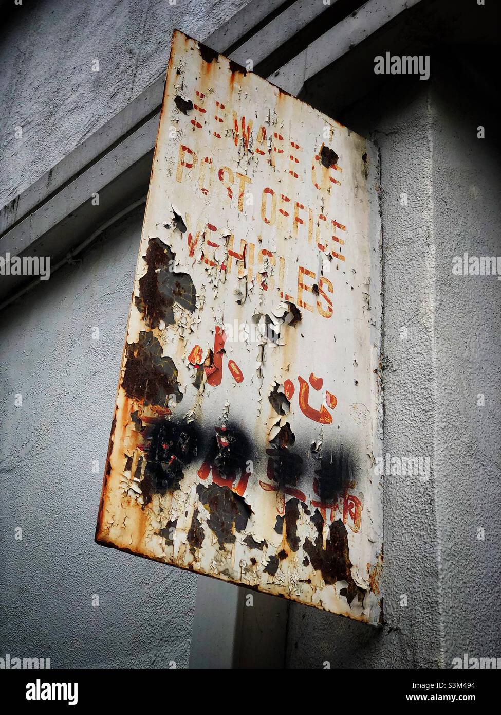 Faded and peeling bi-lingual painted metal cautionary sign, Mong Kok, Kowloon, Hong Kong - Smartphone Captured Stock Image