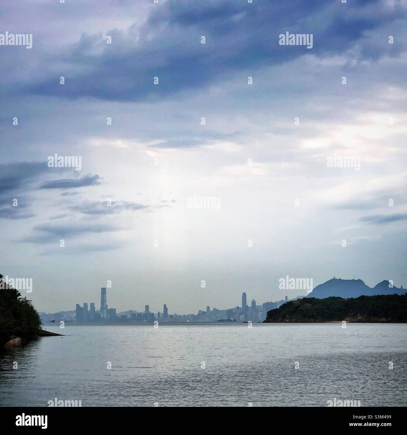 Morning light on an overcast day over the Hong Kong skyline from Tai Pak Bay, Discovery Bay, Lantau Island - Smartphone Captured Stock Image