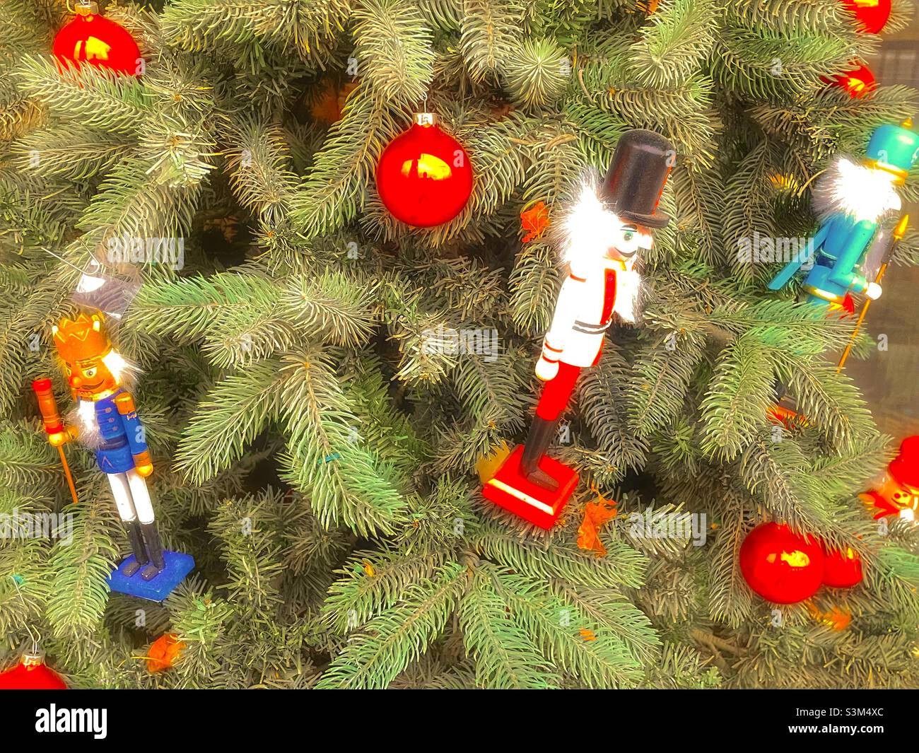 A small apartment patio, in Utah, USA, during the holiday season has a Christmas tree decorated with red ornaments and nutcrackers. - Smartphone Captured Stock Image