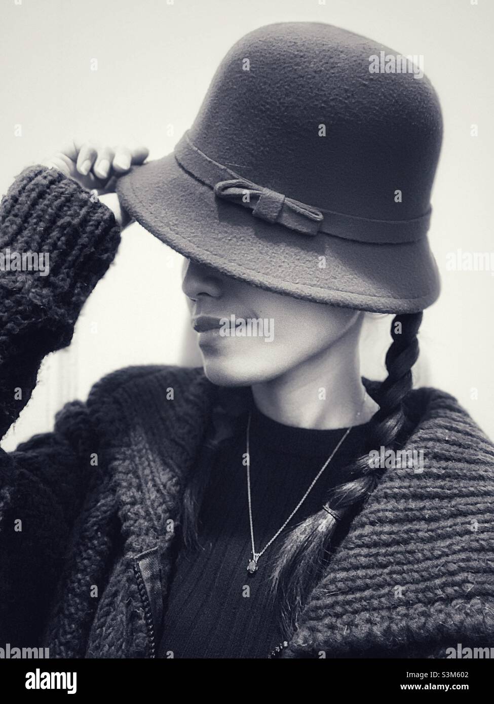A woman’s pose holding her hat in black and white. - Smartphone Captured Stock Image