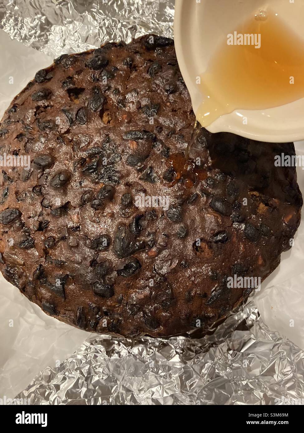Feeding the Christmas cake with ginger wine - Smartphone Captured Stock Image