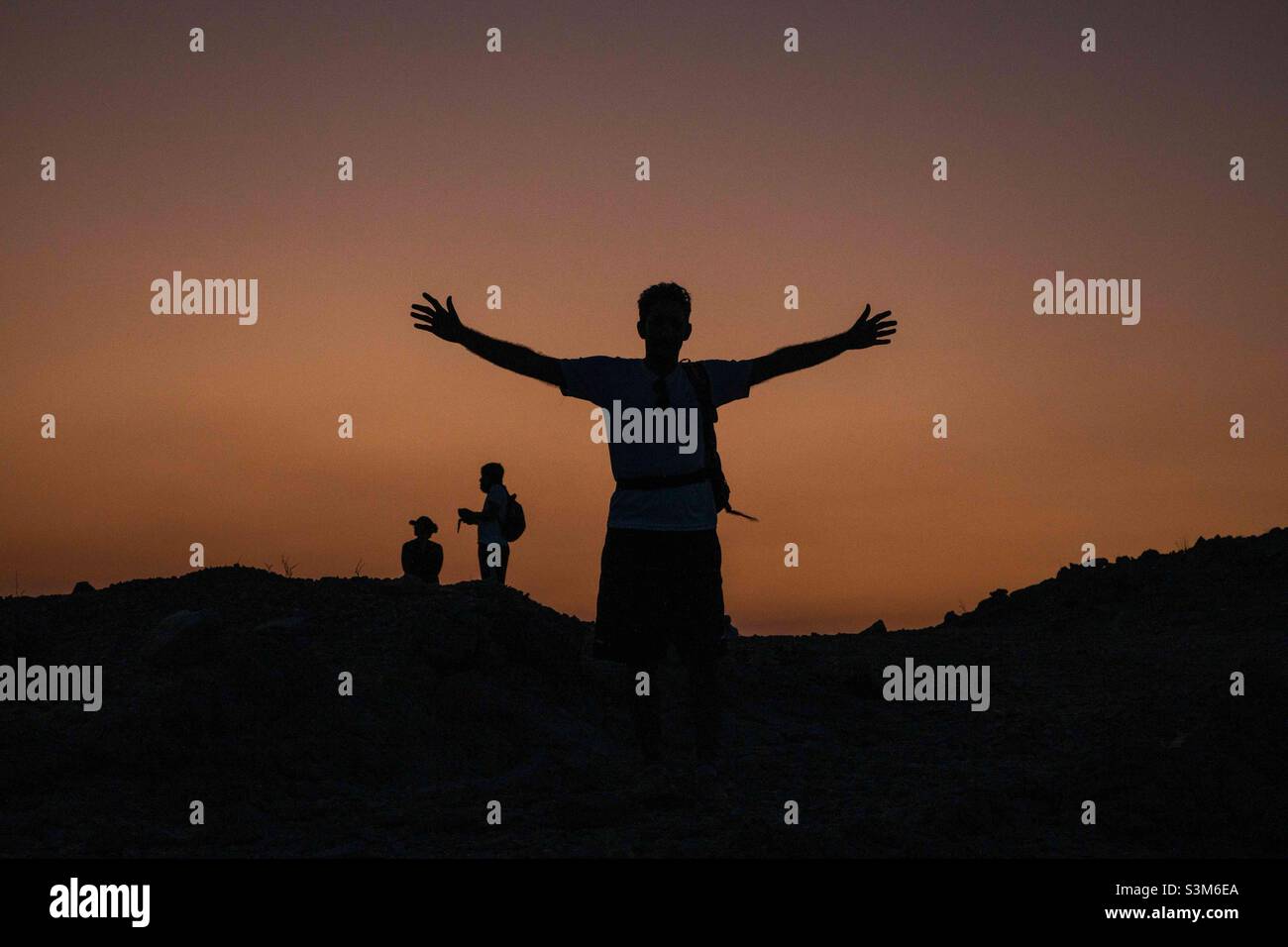 Embracing Life: a silhouette of hikers at sunset - Smartphone Captured Stock Image