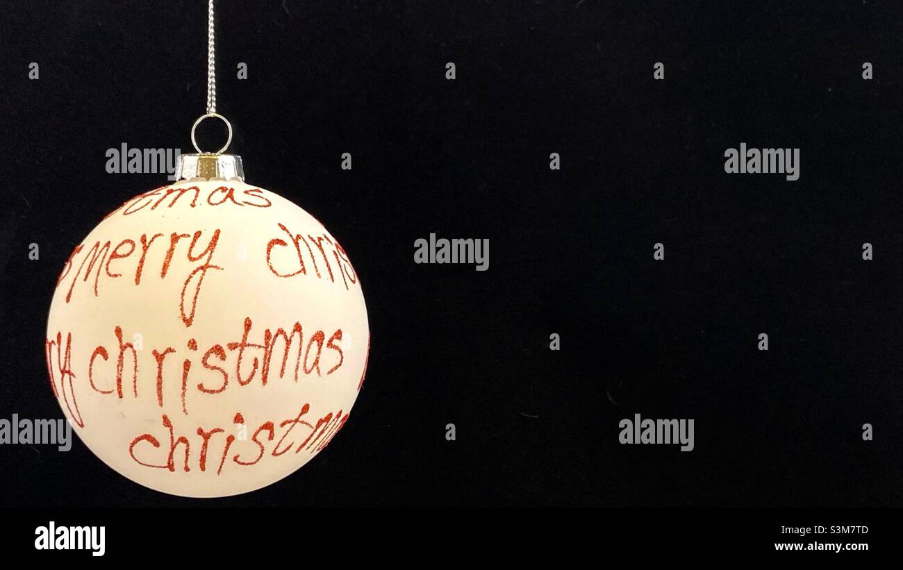 Merry Christmas Bauble against a black background with room for text. - Smartphone Captured Stock Image