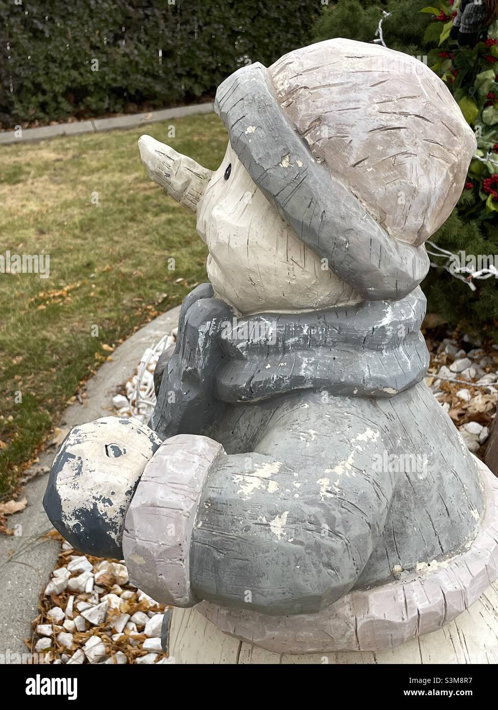 A snowman statue sits in a front yard during the Christmas, and winter, season at a home in Utah, USA. - Smartphone Captured Stock Image