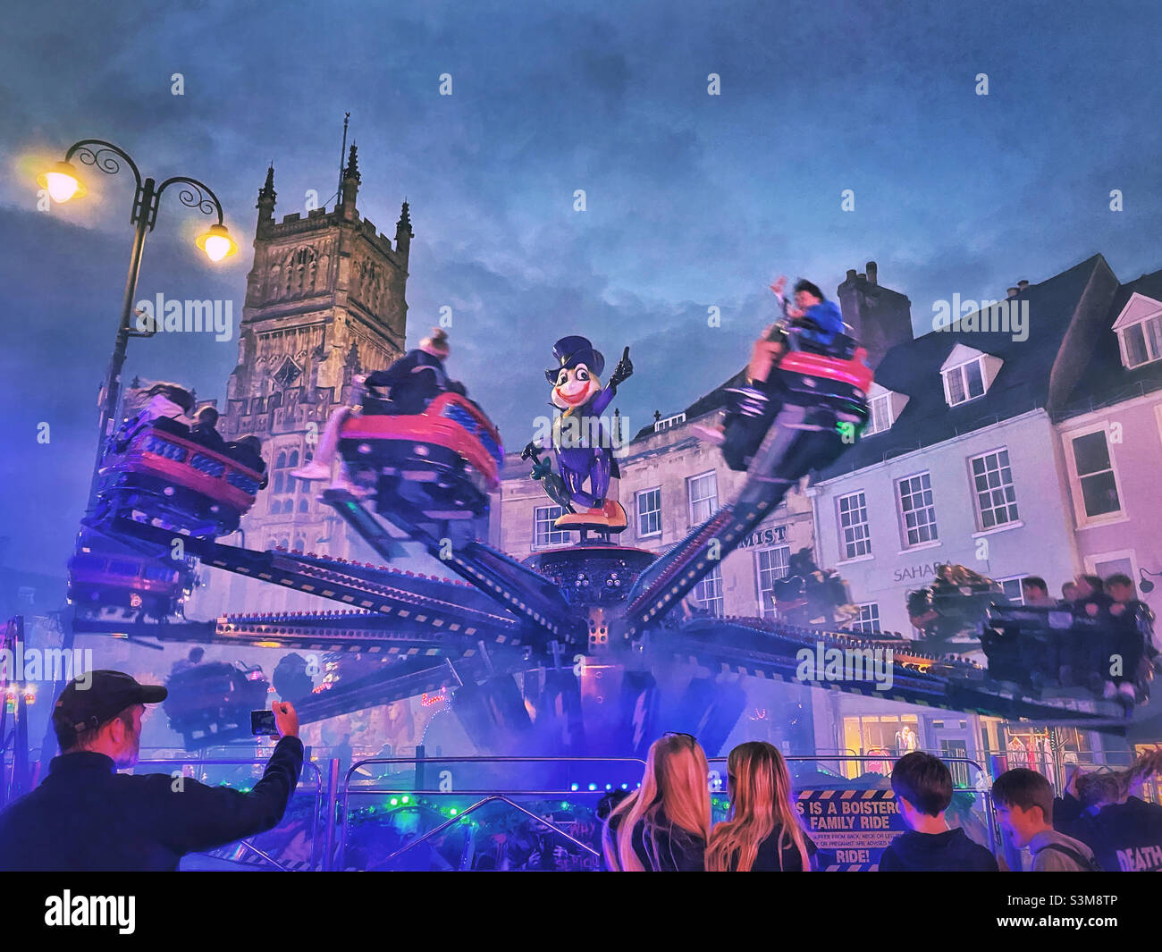 Excitement at the Octopus ride! The annual funfair visits a small town in Gloucestershire, England and many people enjoy the rides and atmosphere. Photo ©️ COLIN HOSKINS. - Smartphone Captured Stock Image