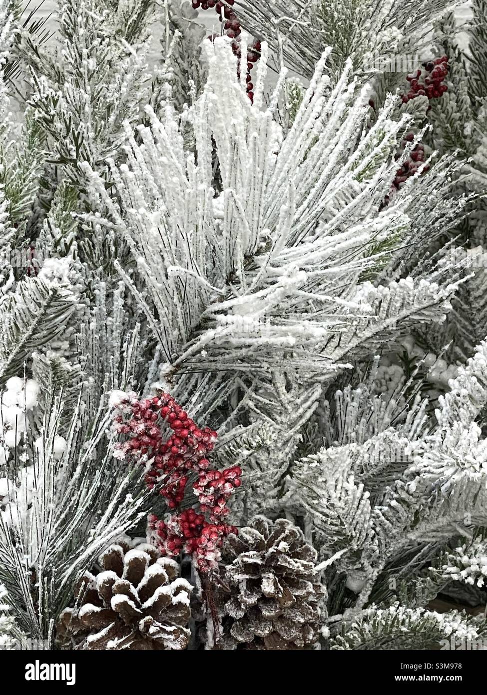 Christmas artificial floral arrangements being sold at a local Walmart in Utah, USA. Very seasonal with green pine needles, red berries and flocking to give it a frosted look. - Smartphone Captured Stock Image