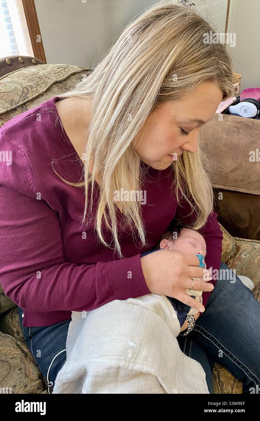 Beautiful blonde woman holding a newborn baby in Roach, Missouri Stock Photo
