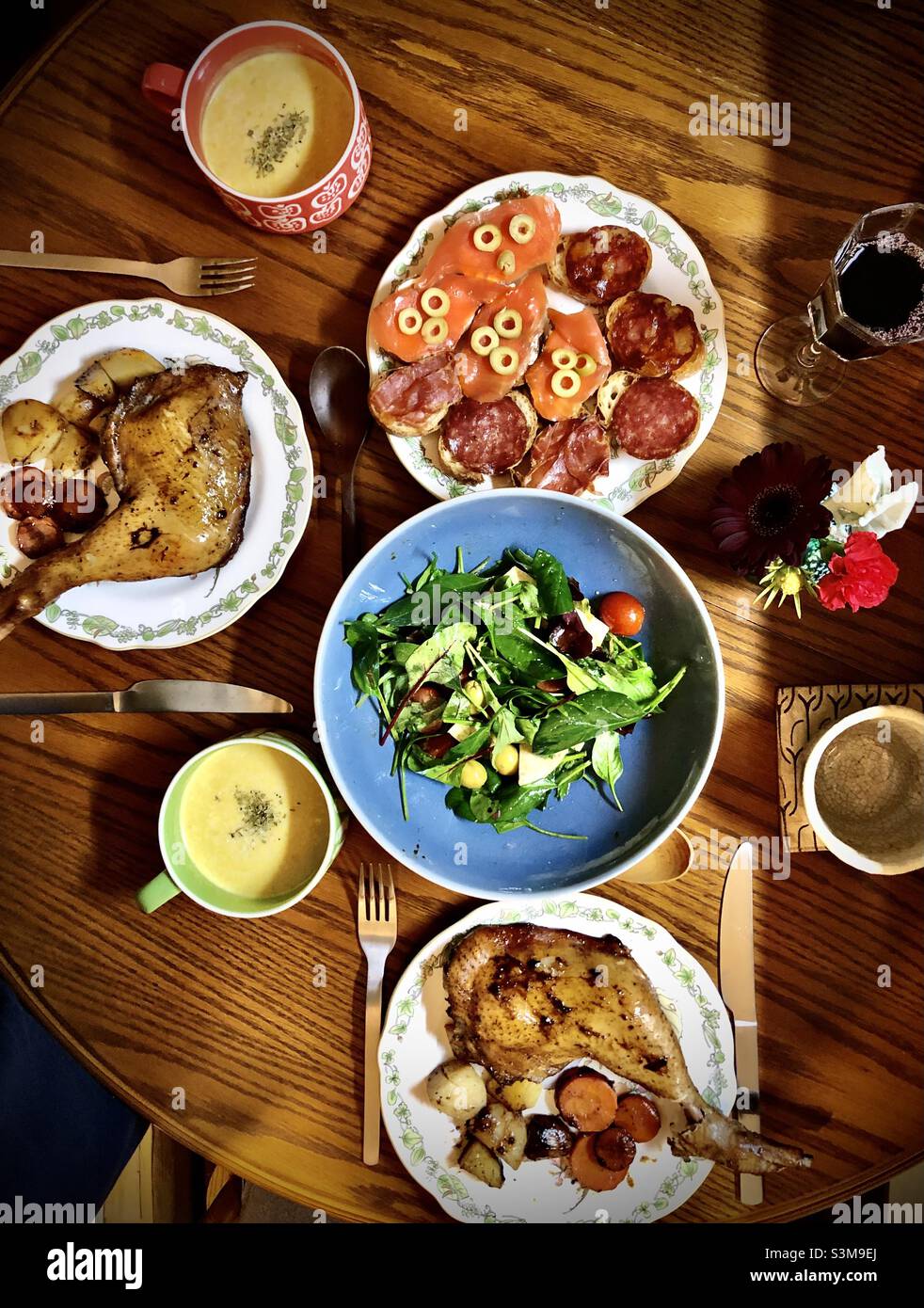 Homemade Christmas dinner for two: roasted chicken, baby leaves salad, smoked salmon and salami on toast - Smartphone Captured Stock Image