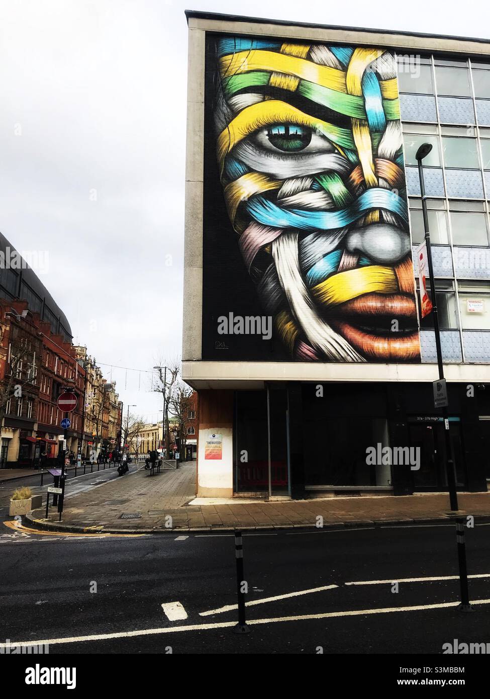 Street art painting half face with coloured ribbon on a building front wall in Croydon town centre Stock Photo