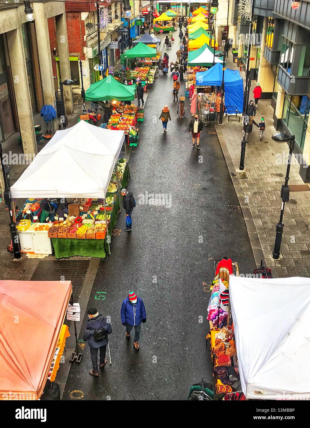 Top view of open air Surrey street market with colourful marquee tents and people shopping Stock