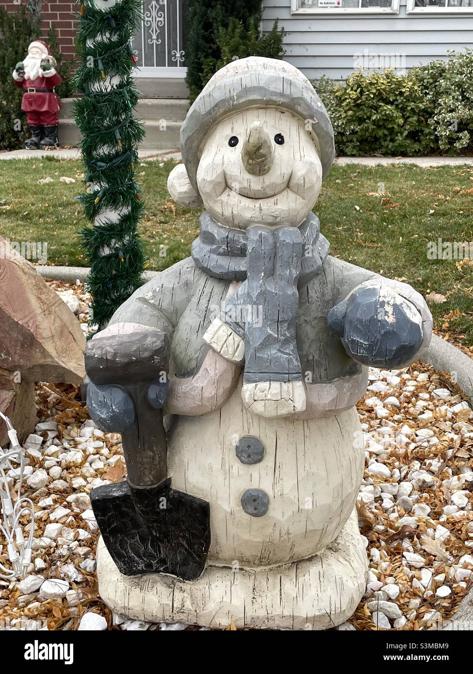 A cheerful snowman is an annual yard decor during the Christmas and winter seasons at a home in Utah, USA. Santa can be seen in the background. - Smartphone Captured Stock Image