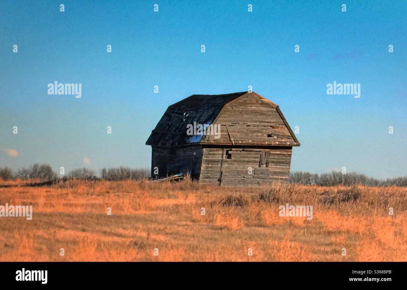 Historic barn, old, abandoned, unused, sagging, weathered, unpainted, broken, prairie, farm - Smartphone Captured Stock Image