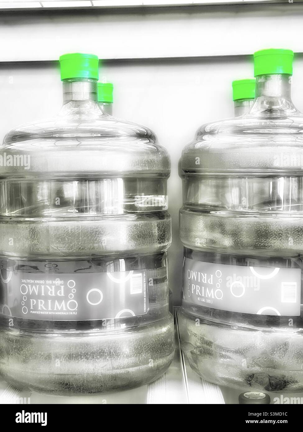 5 gallon bottles of purified, filtered water are seen on a rack for sale at a recycling kiosk