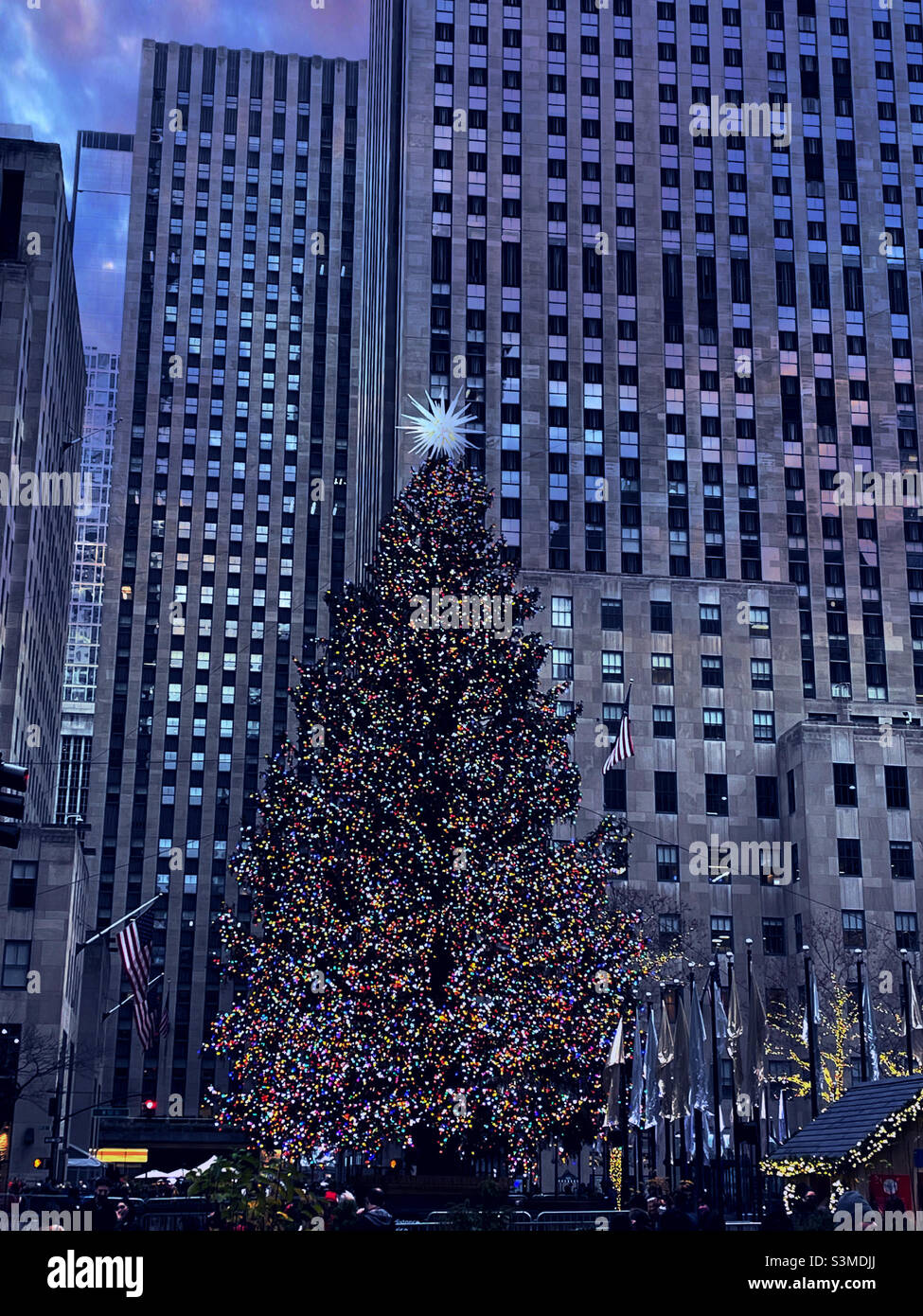 The iconic Christmas tree at Rockefeller Center shines brightly on a crystal clear winter night during the holiday season in Midtown Manhattan, 2021, New York City, USA - Smartphone Captured Stock Image