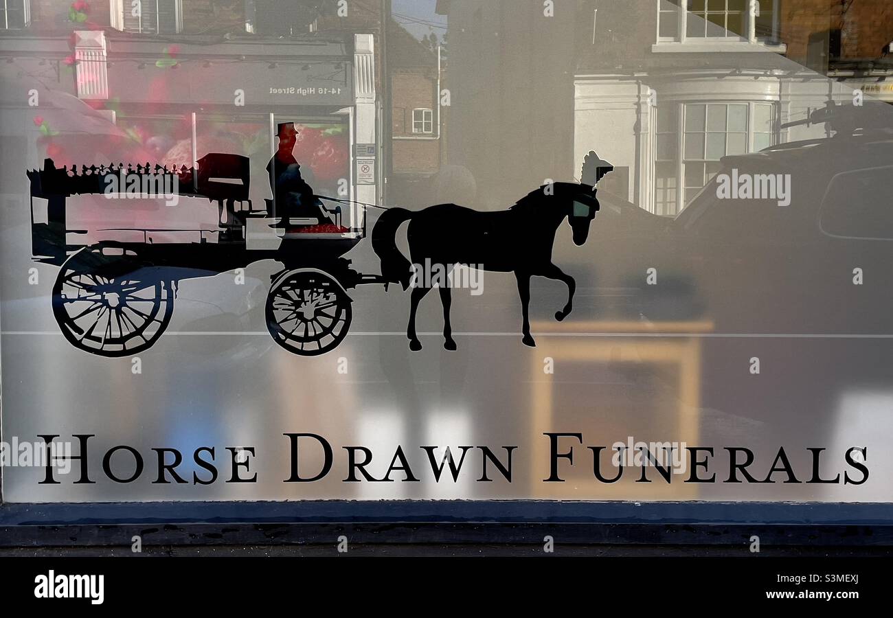 An image of a horse-drawn hearse on the window of an undertakers premises in Upton upon Severn - Smartphone Captured Stock Image