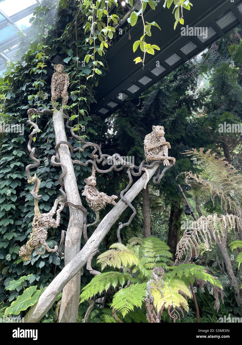 Monkeys made of wood sitting on a branch Stock Photo