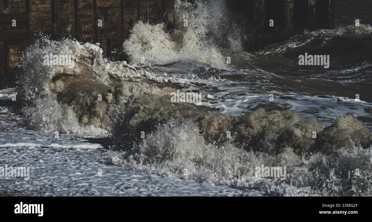 Rolling waves of the English Channel crash into wooden breakers - Smartphone Captured Stock Image